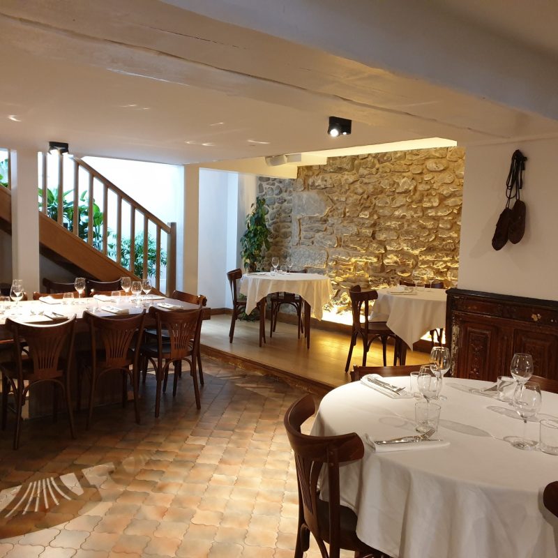 grande salle de restaurant avec une table ronde et nappe blanche
